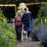 Mother and Son walking a dog in a field